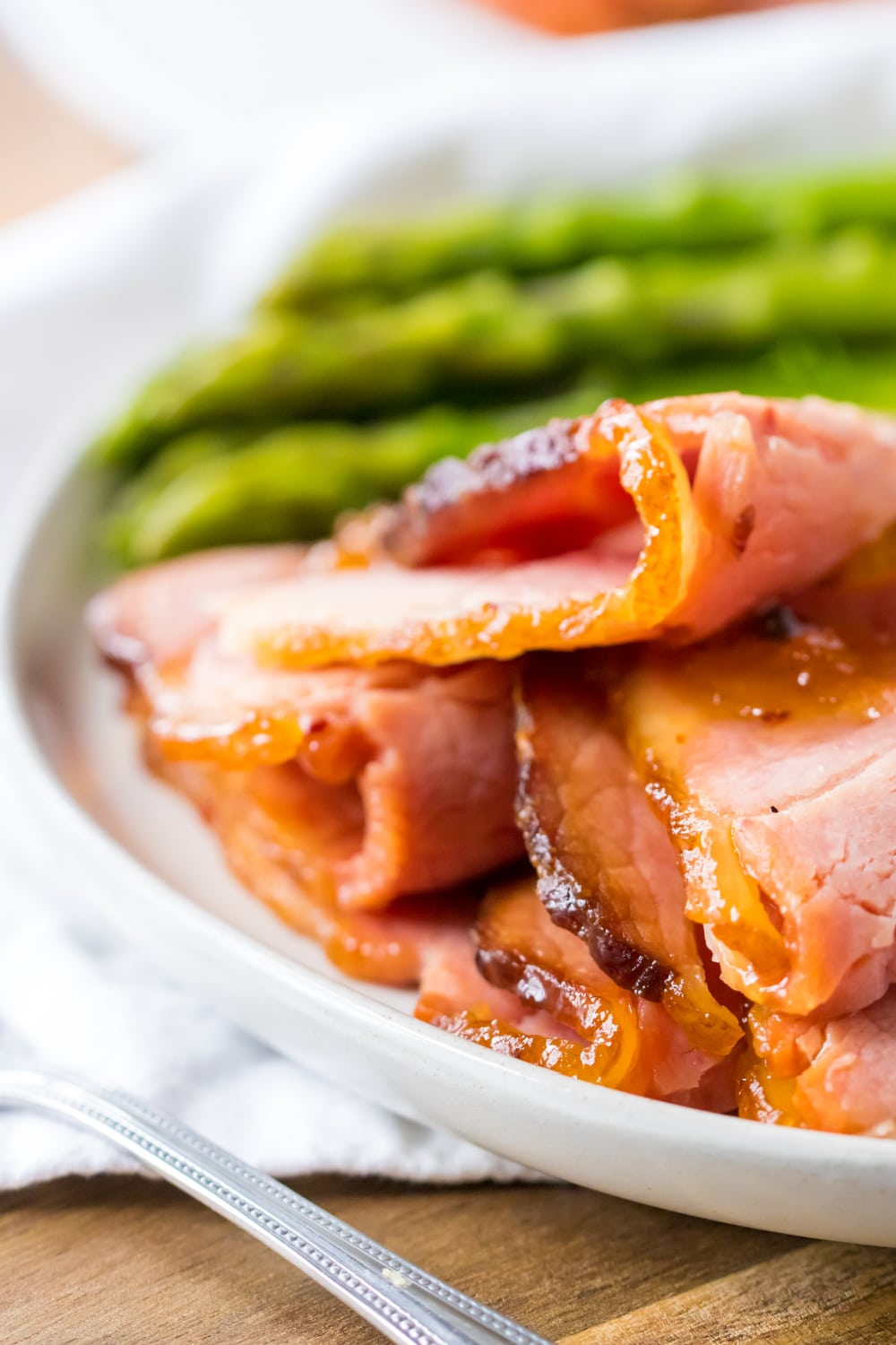 close up of slices of hot honey ham on a white plate