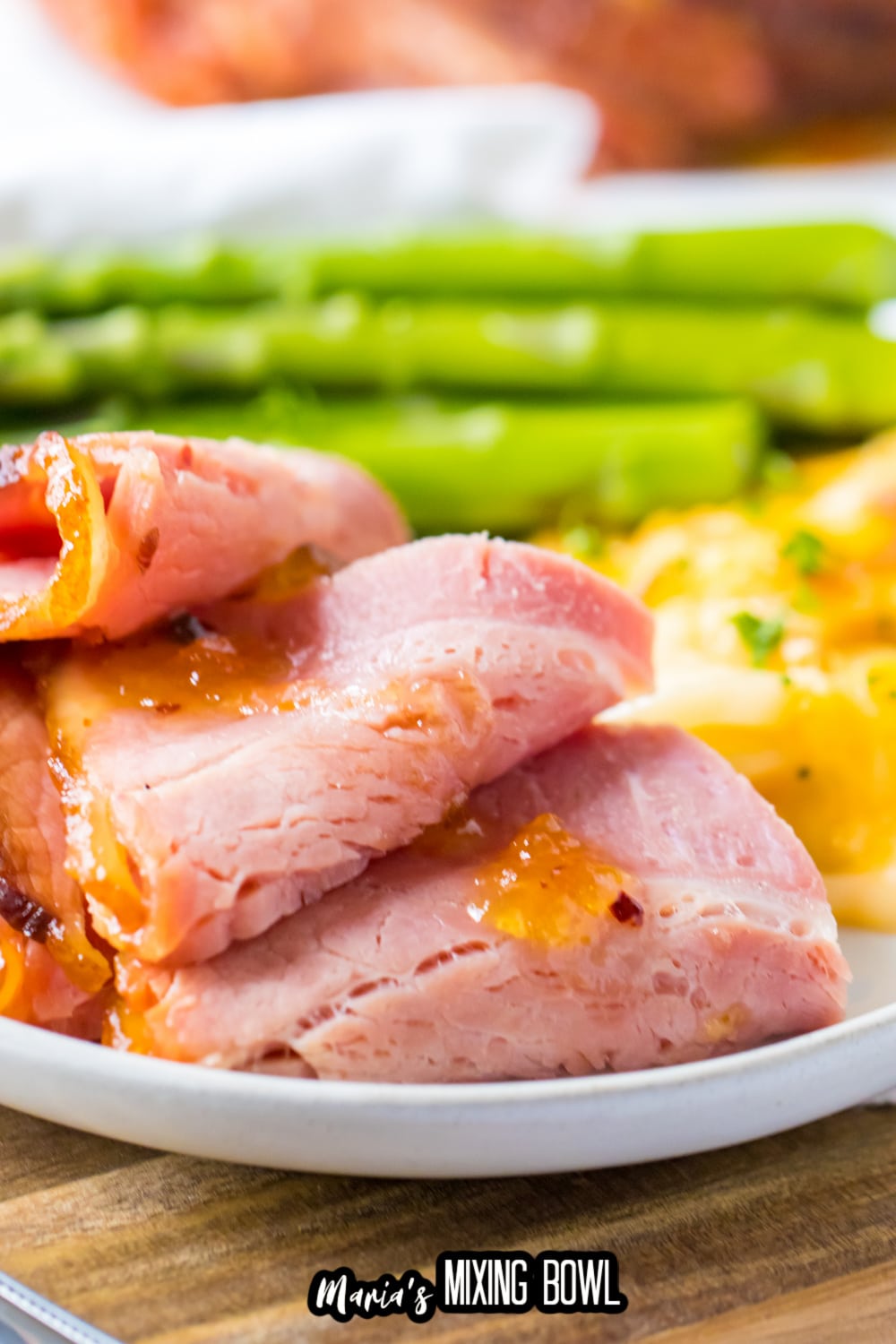 close up of slices of hot honey ham on a white plate