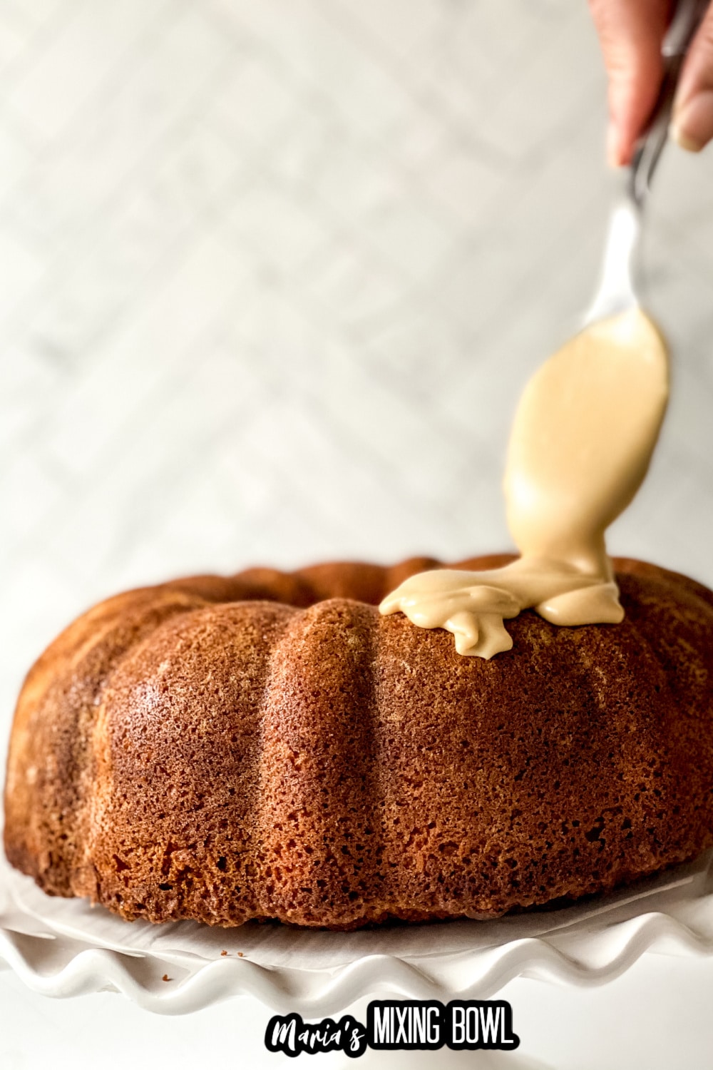 frosting being poured on a bundt cake