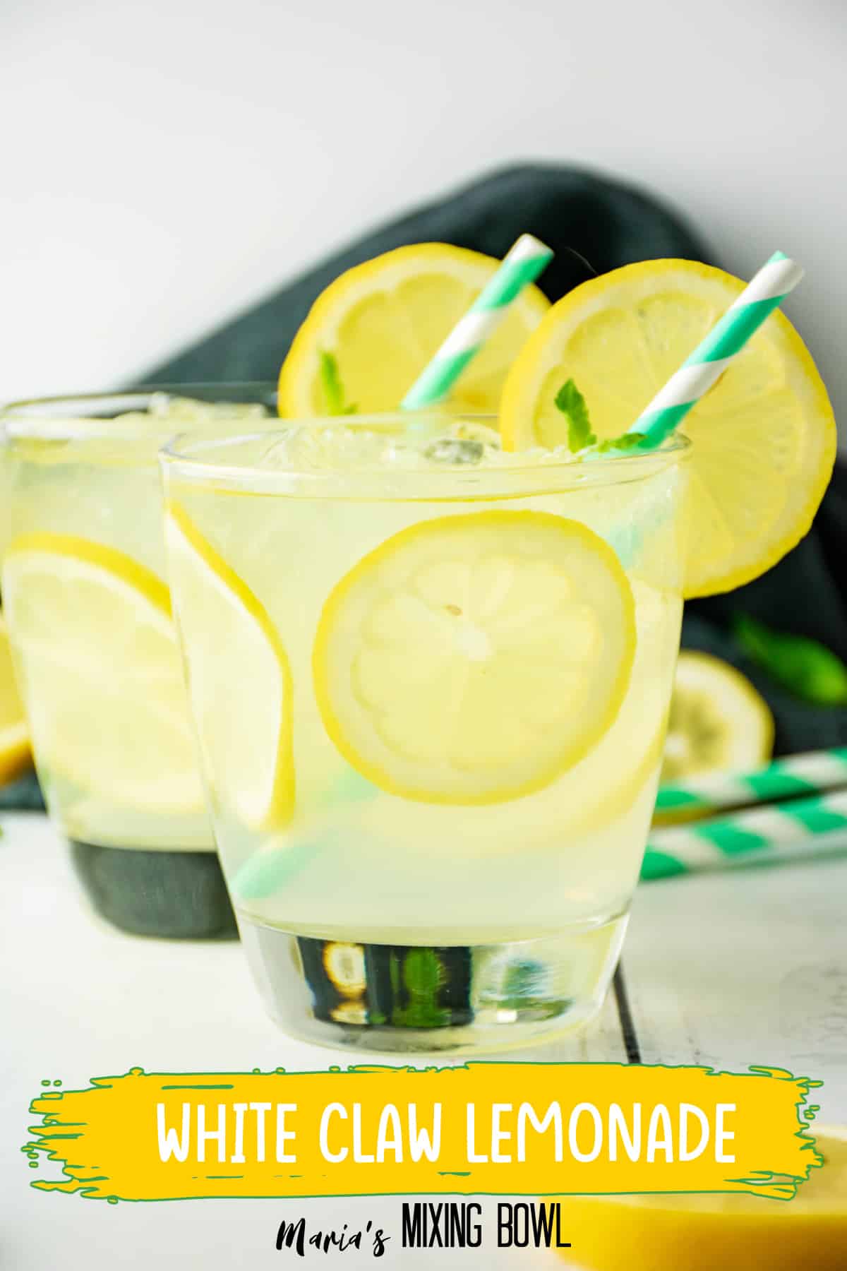two cocktail glasses filled with lemon cocktail with a green and white straw