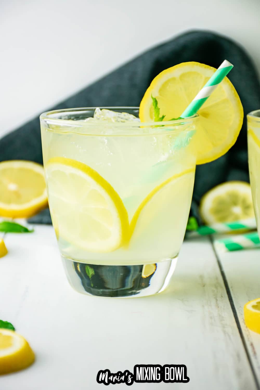 cocktail glass filled with lemon cocktail with a green and white straw