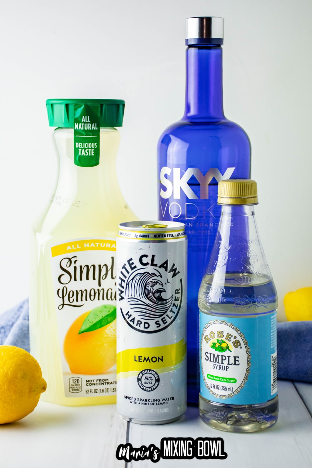 bottles of simply lemonade, white claw, vokda, simple syrup and a lemon on a white background