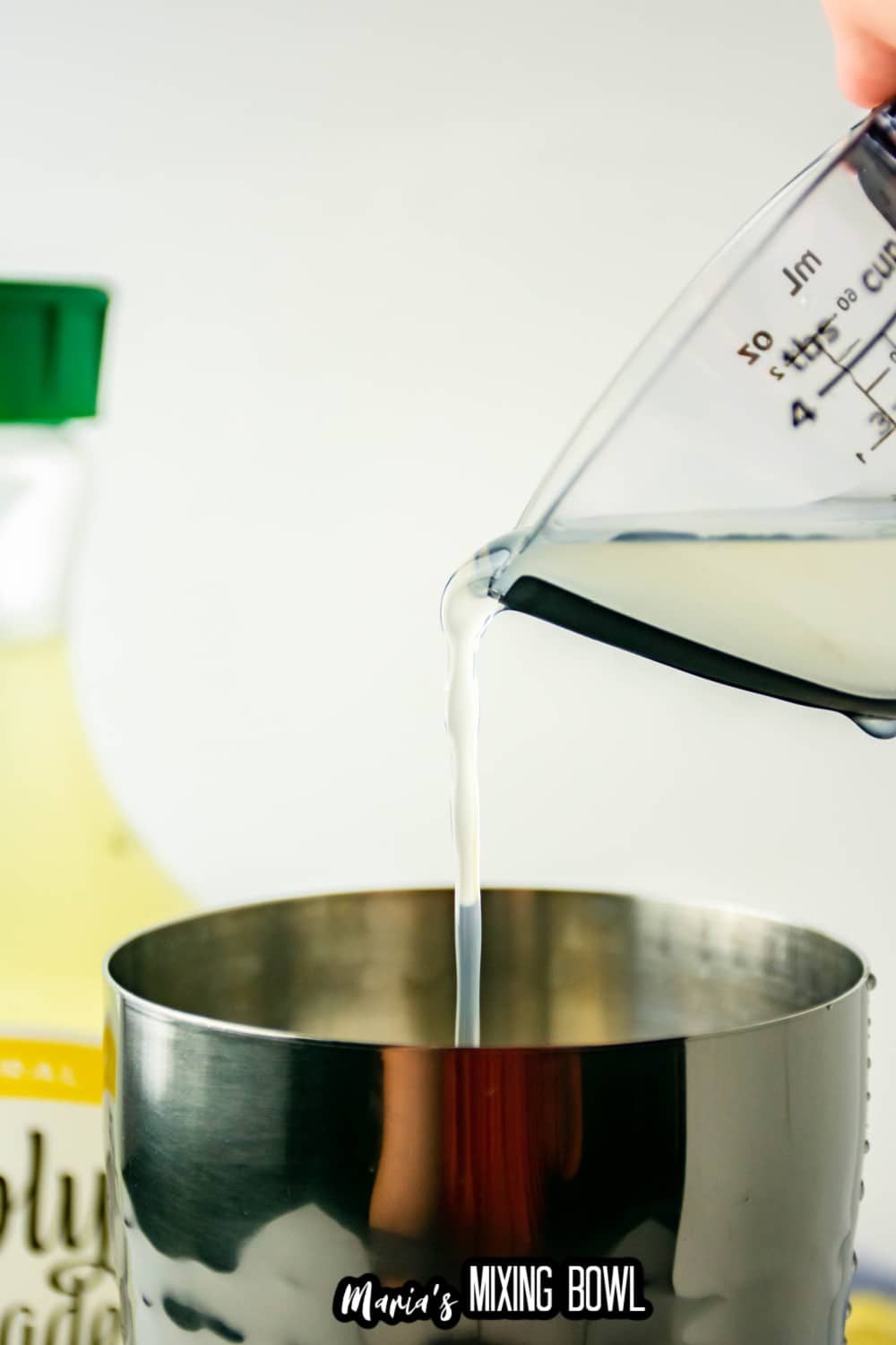 lemonade being poured into a cocktail shaker