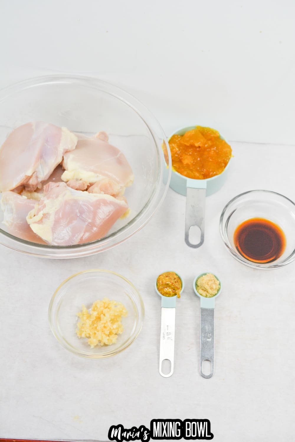 chicken thighs, apricot jam, garlic, soy sauce, mustard, and ginger paste on a white background