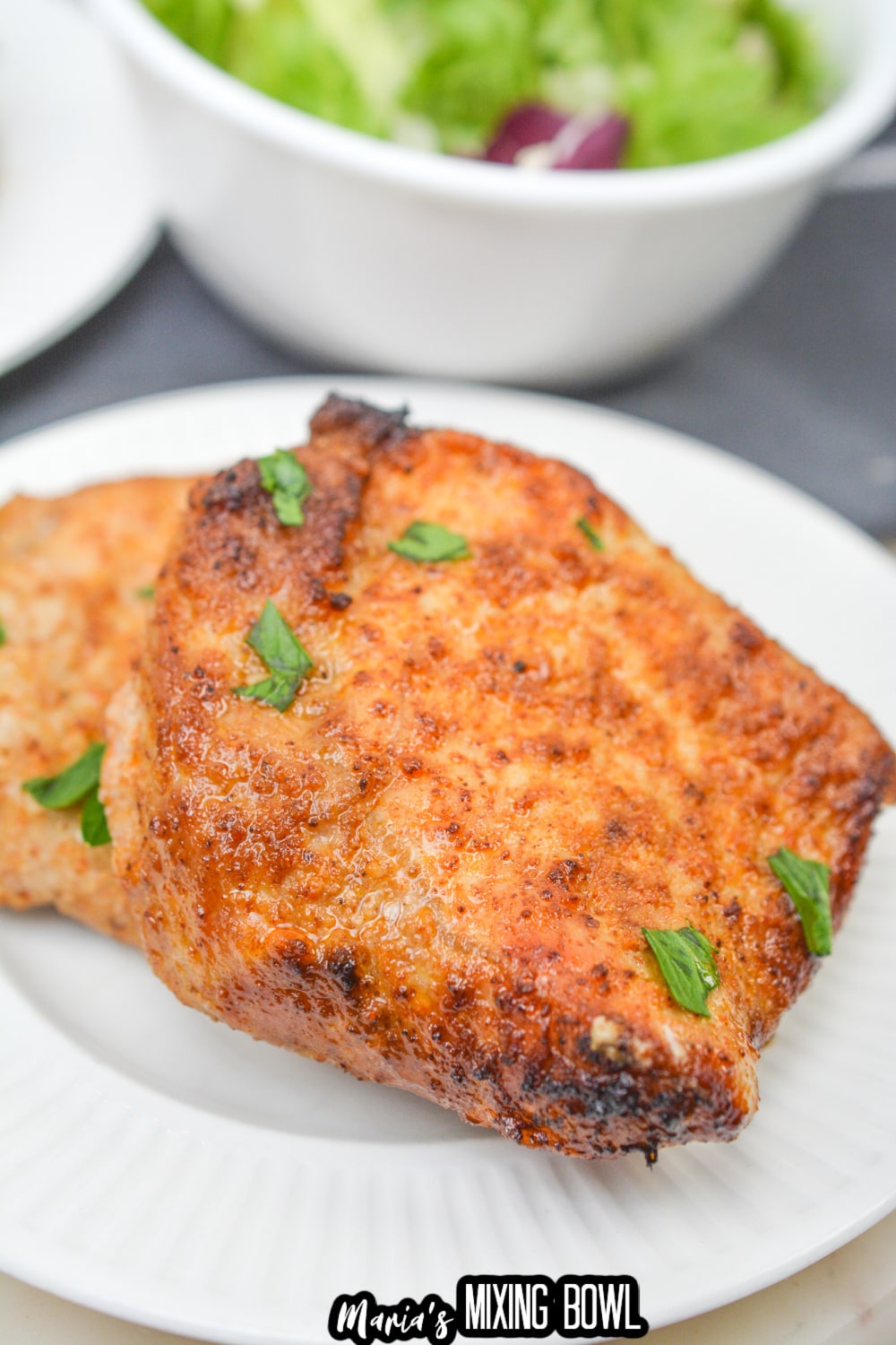 two air fryer pork chops on a white plate