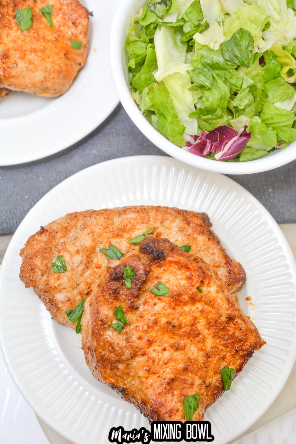 two air fryer pork chops on a white plate