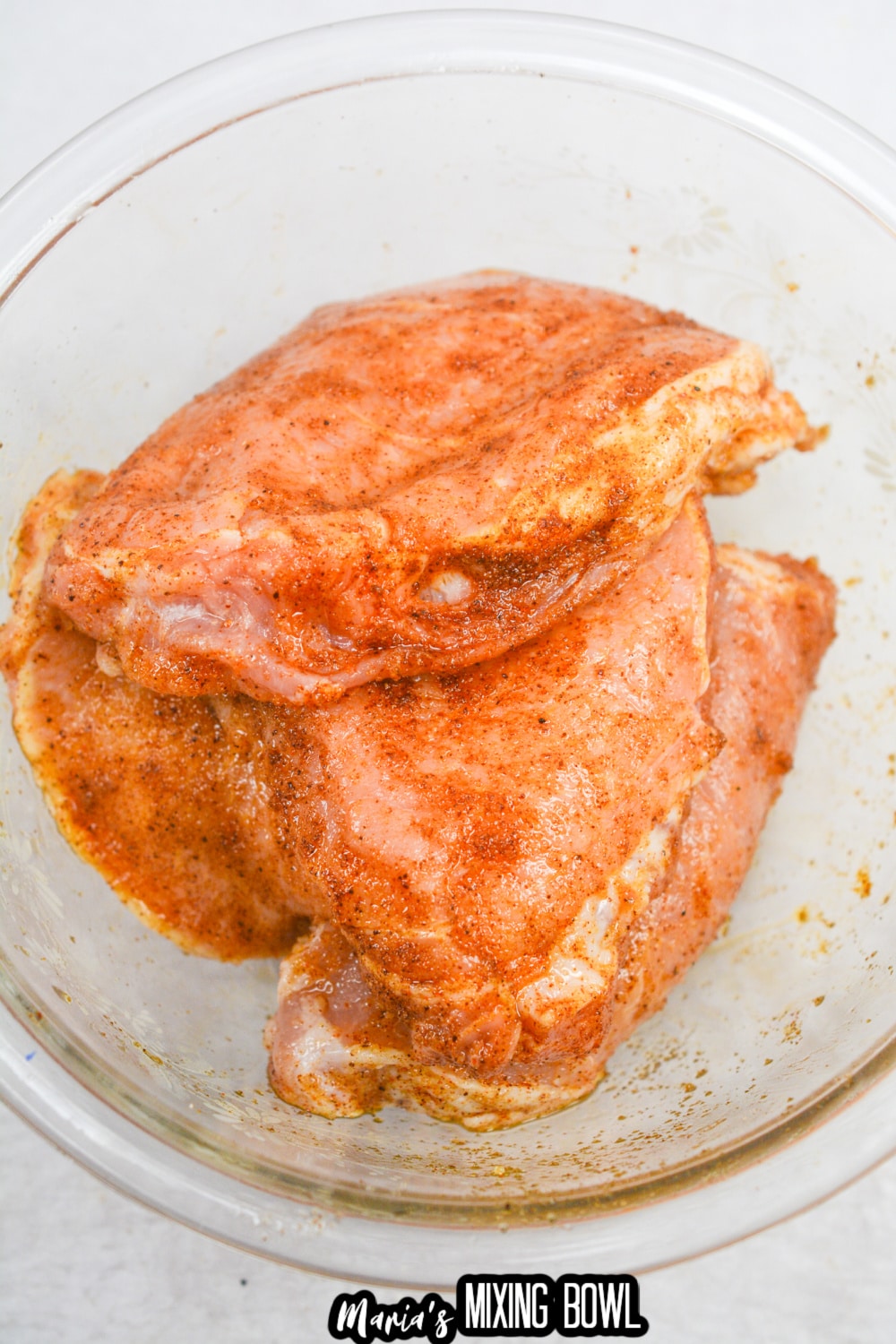 seasoned pork chops in a glass mixing bowl