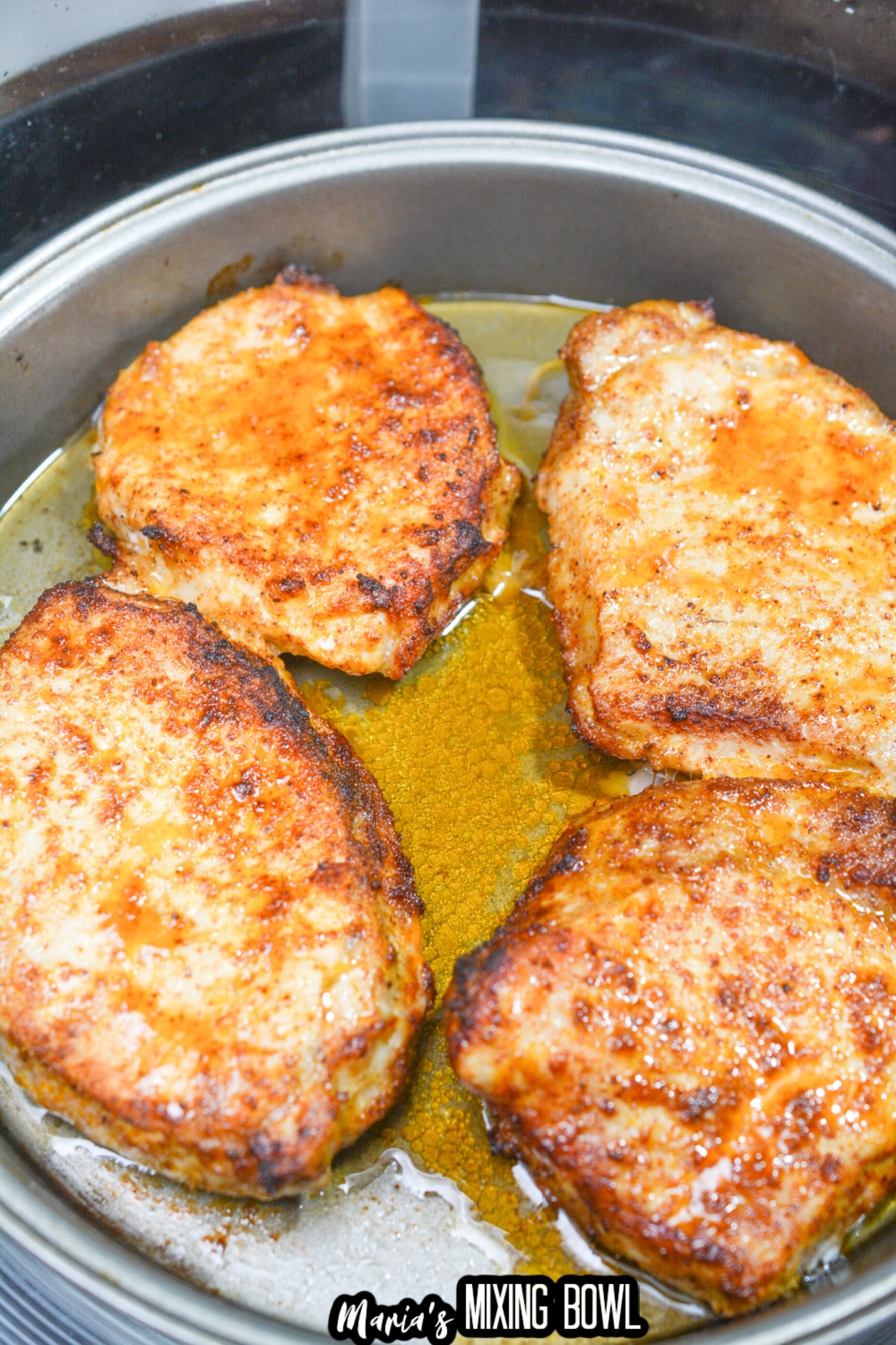four cooked pork chops in a metal cake pan