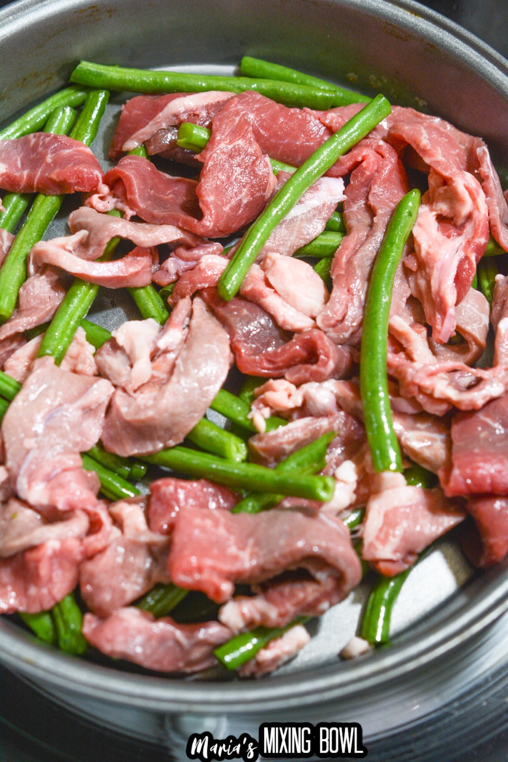 green beans and sliced beef in a cake pan