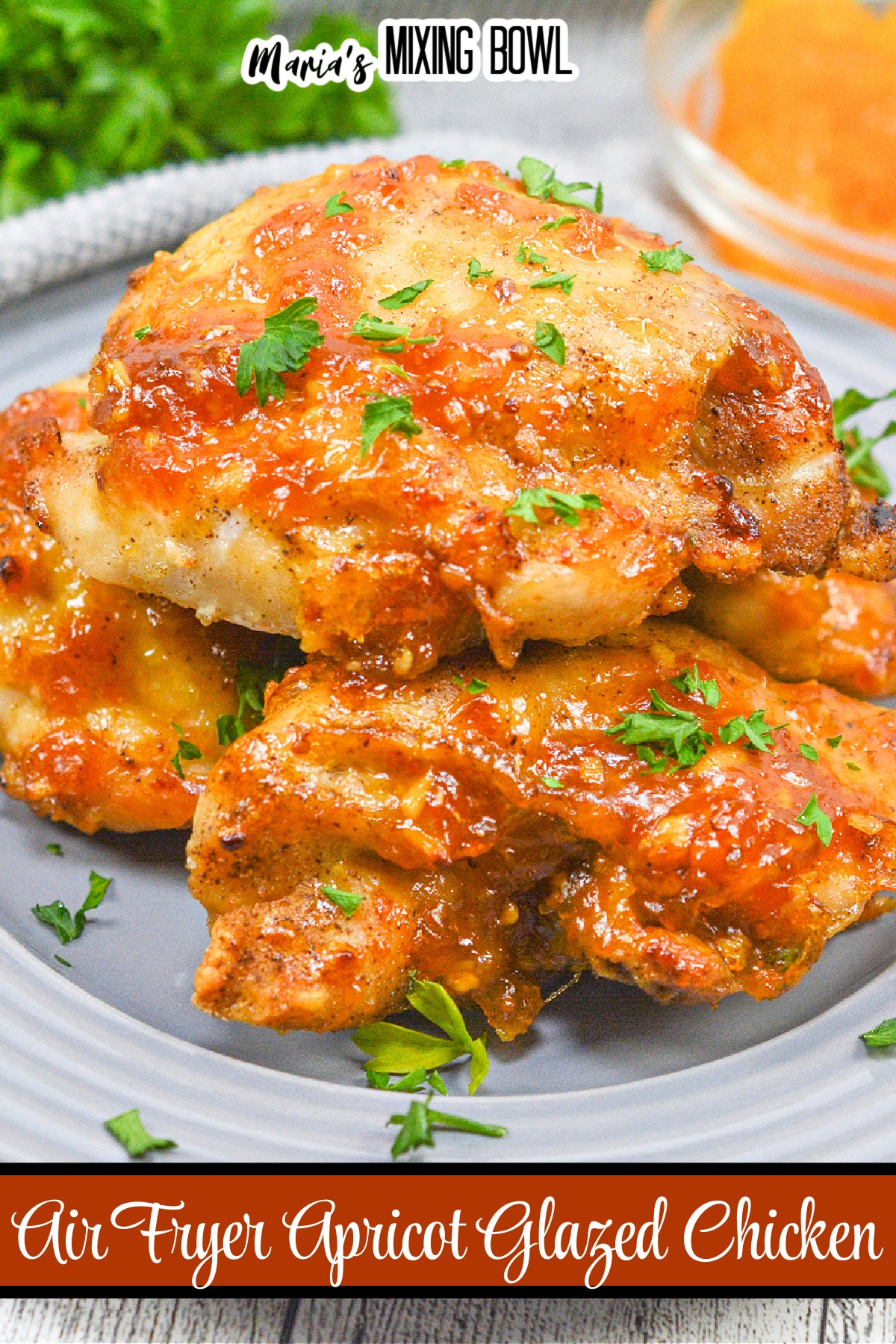 apricot glazed chicken thighs stacked on a gray plate