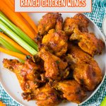 stack of chicken wings on a white plate with celery and carrot sticks