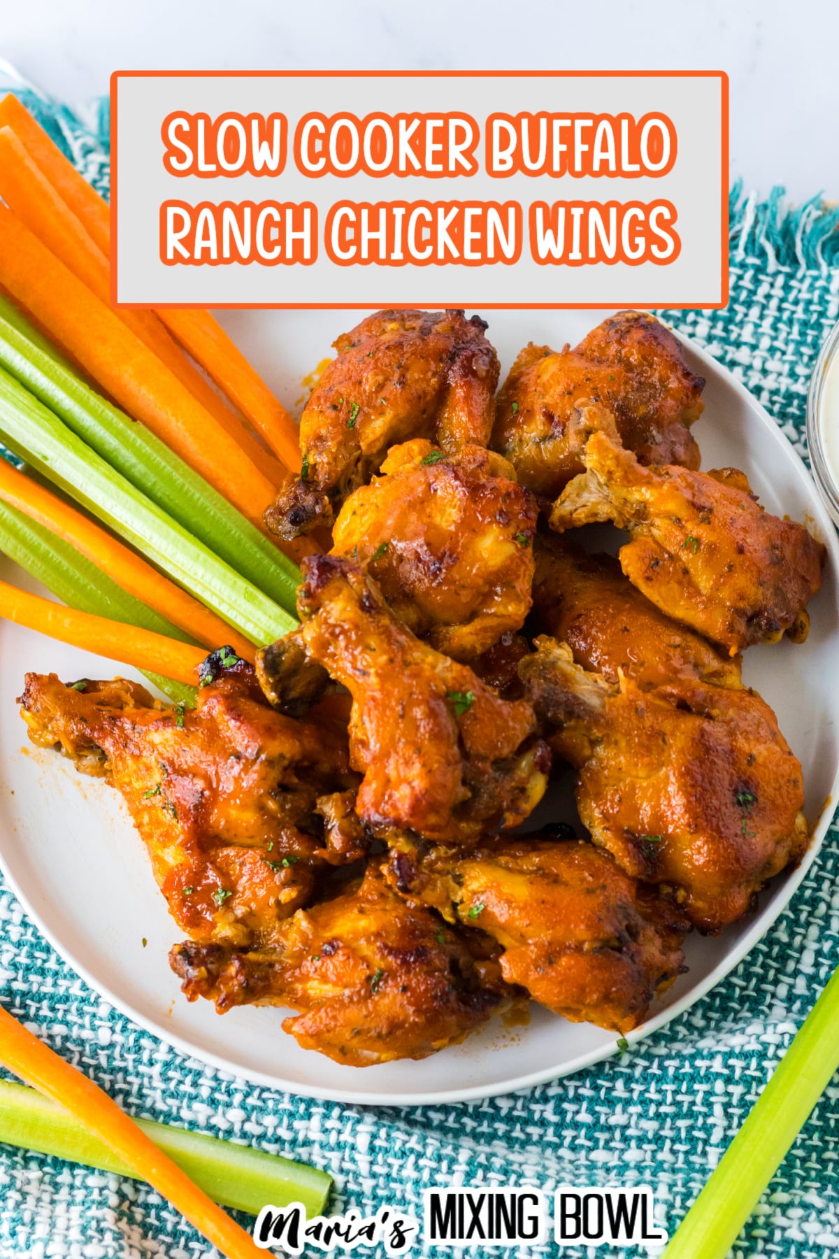 stack of chicken wings on a white plate with celery and carrot sticks