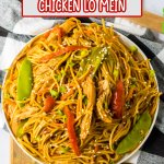 white plate filled with chicken lo mein and a bell pepper in the background
