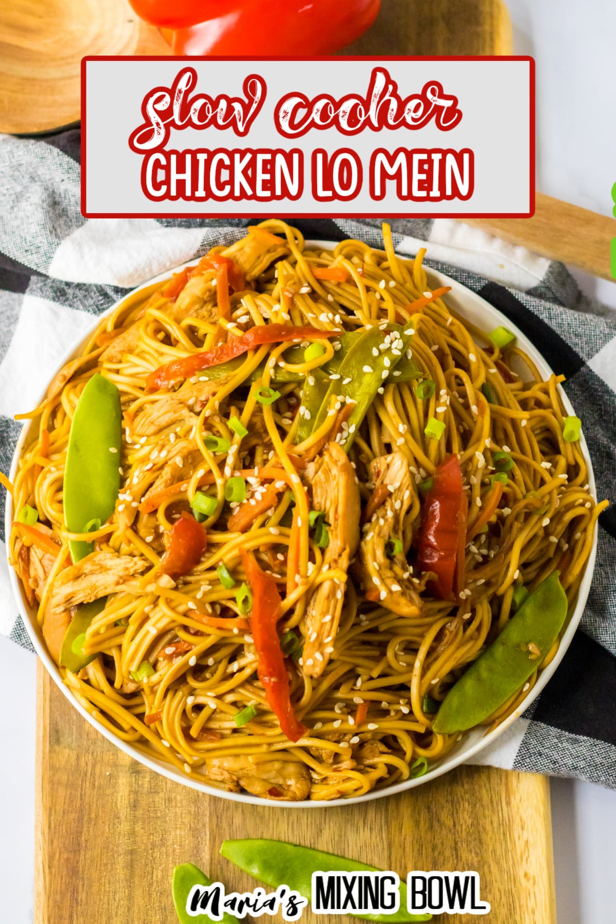 white plate filled with chicken lo mein and a bell pepper in the background