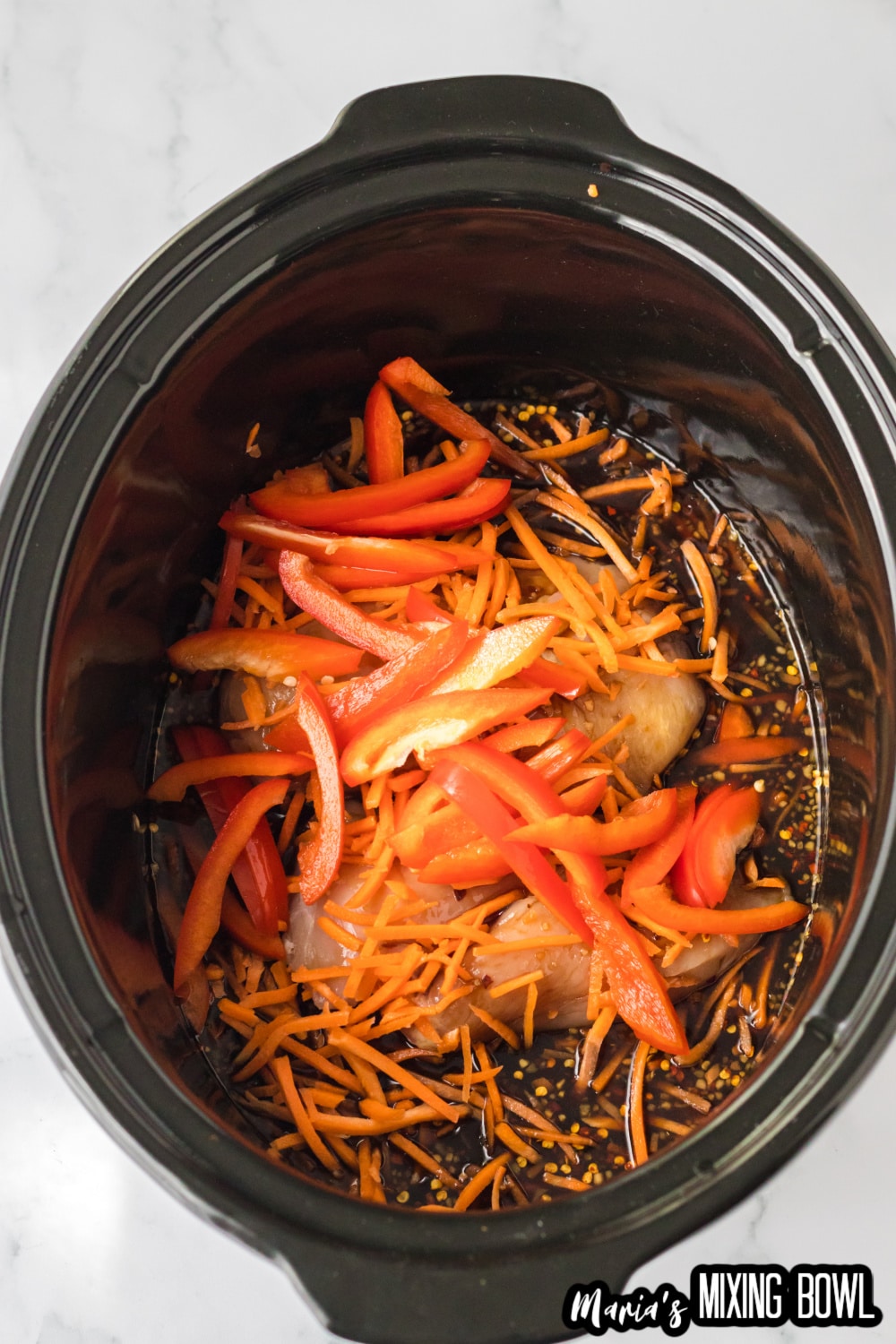 peppers, chicken, carrots and sauce in a slow cooker