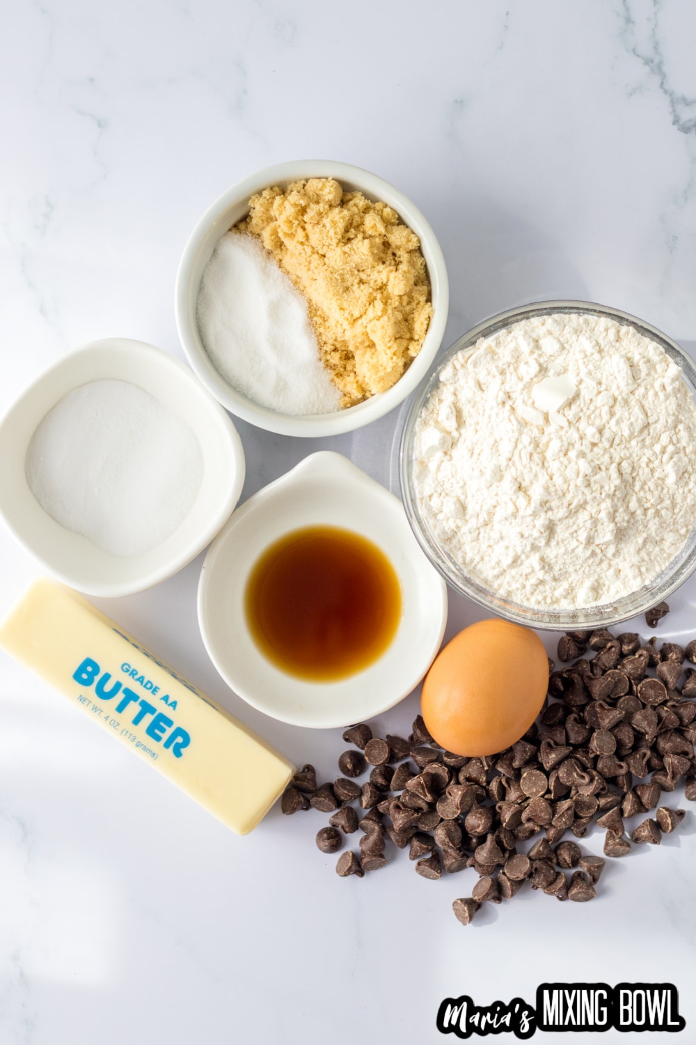 sugar, flower, baking powder, vanilla, egg, butter, and chocolate chips on a white background