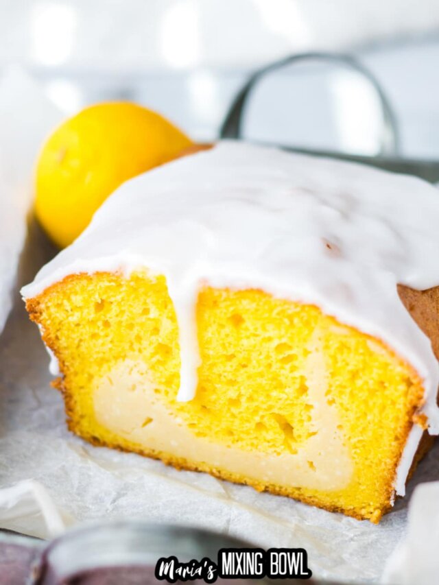 lemon loaf topped with glaze cut in half to show the inside