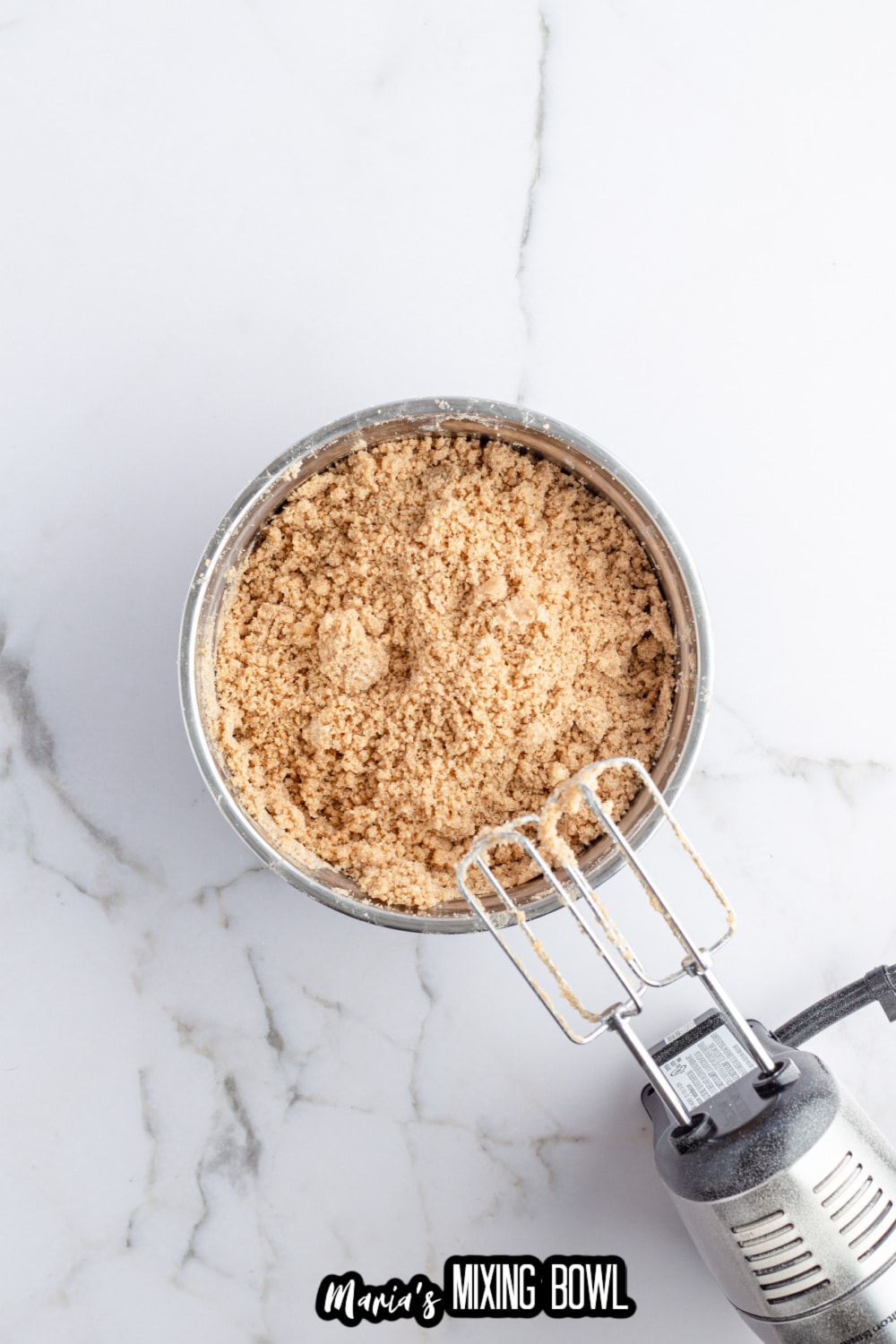 crumb topping being mixed in a stainless steel mixing bowl