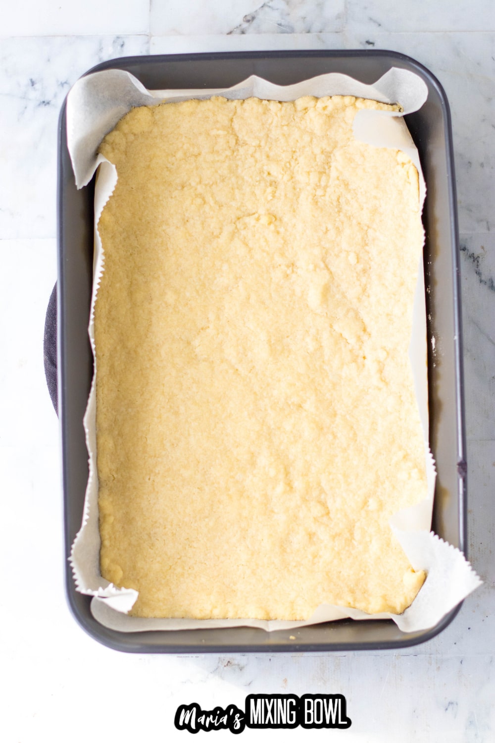 shortbread baking into a parchment lined baking dish