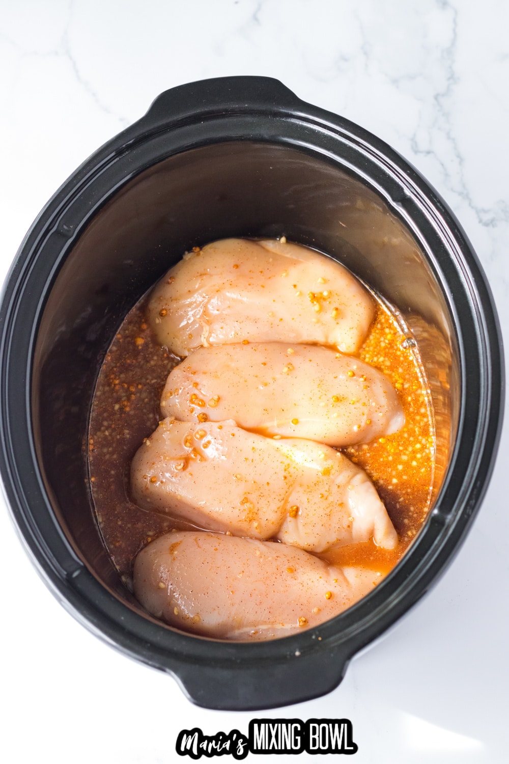 raw chicken in sauce in a slow cooker