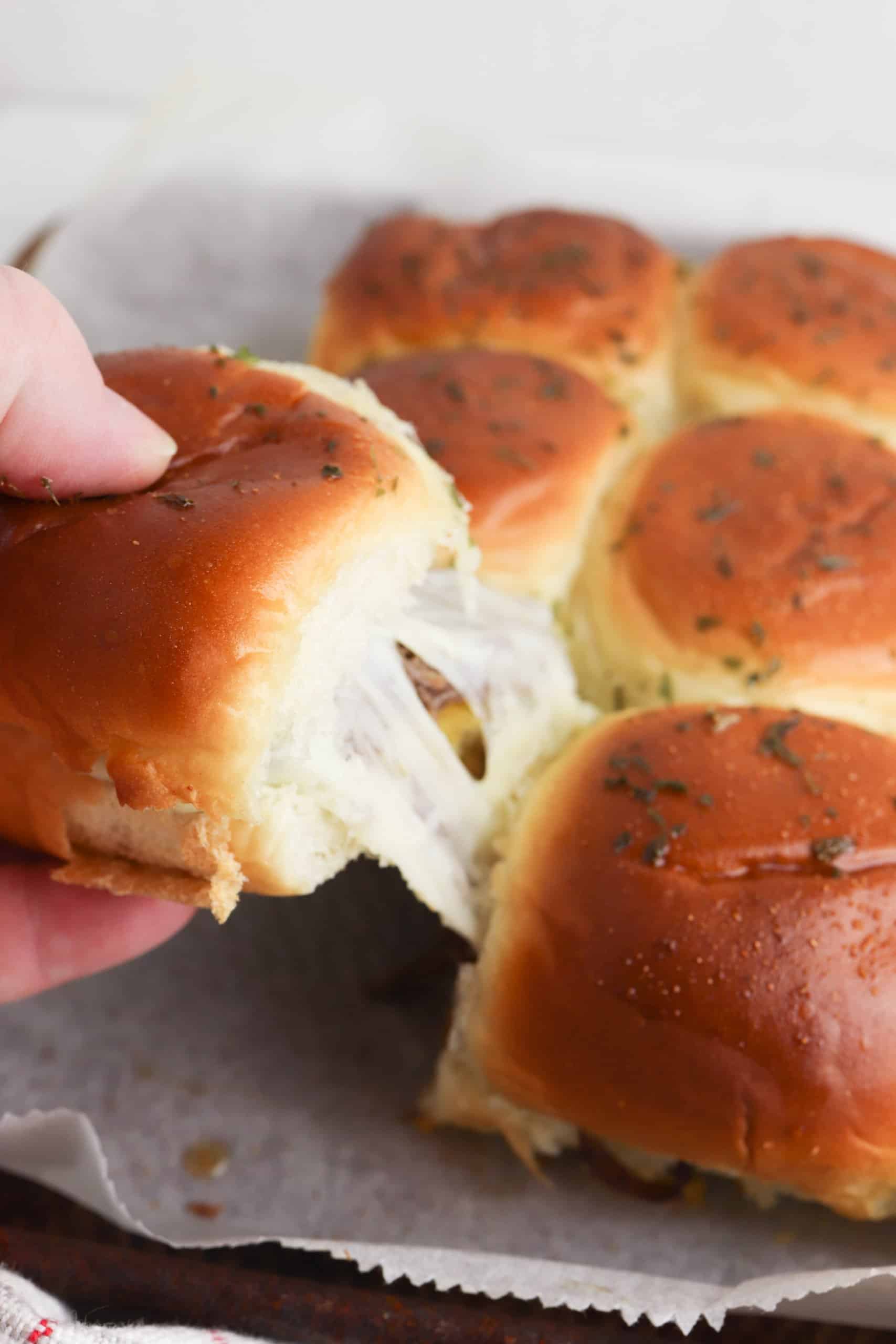 slider being removed from the pan with cheese pull