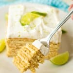 slice of key lime ice box cake on a white plate with lime wedges
