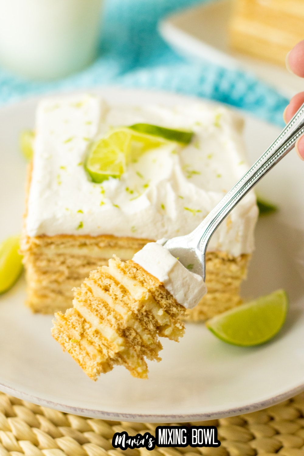 slice of key lime ice box cake on a white plate with lime wedges