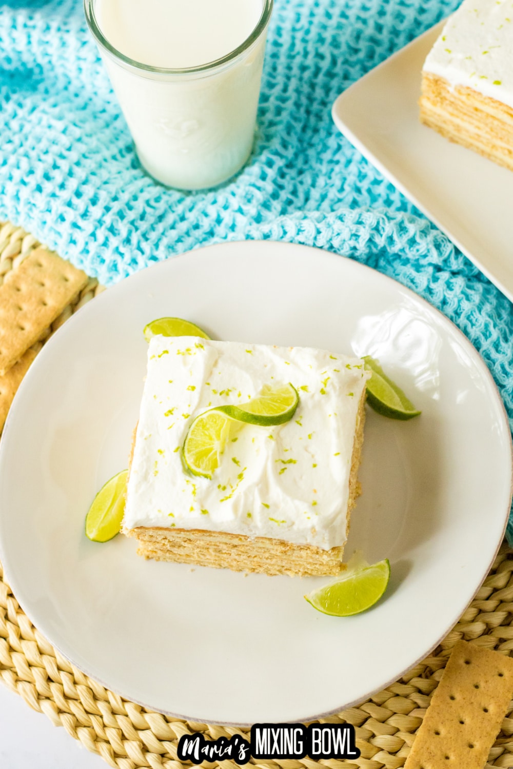 slice of key lime ice box cake on a white plate with lime wedges