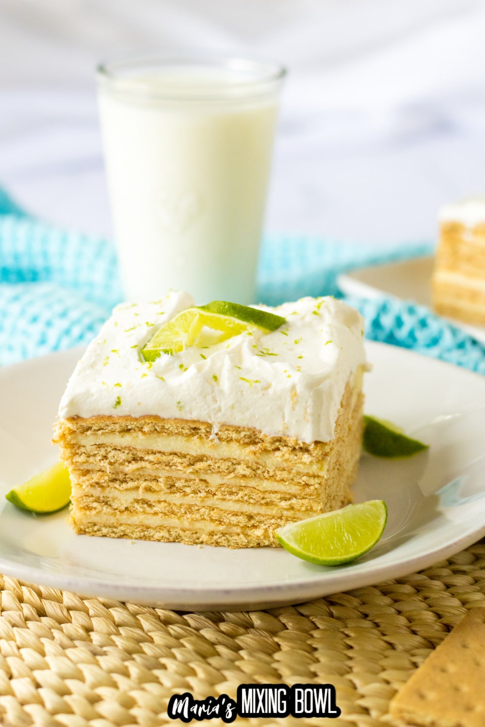 slice of key lime ice box cake on a white plate with lime wedges