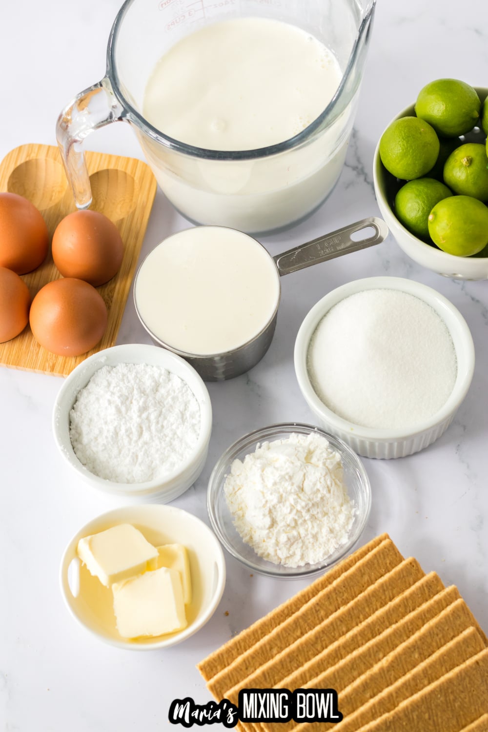 half and half, eggs, limes, heavy cream, powdered sugar, granulated sugar, butter, cornstarch, and graham crackers on white background
