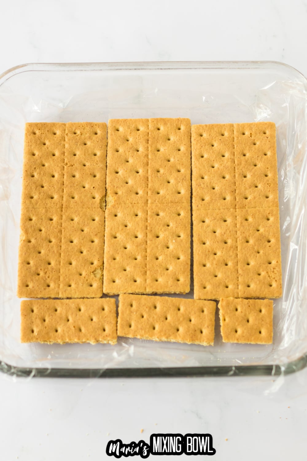 graham crackers in a plastic wrap lined baking dish