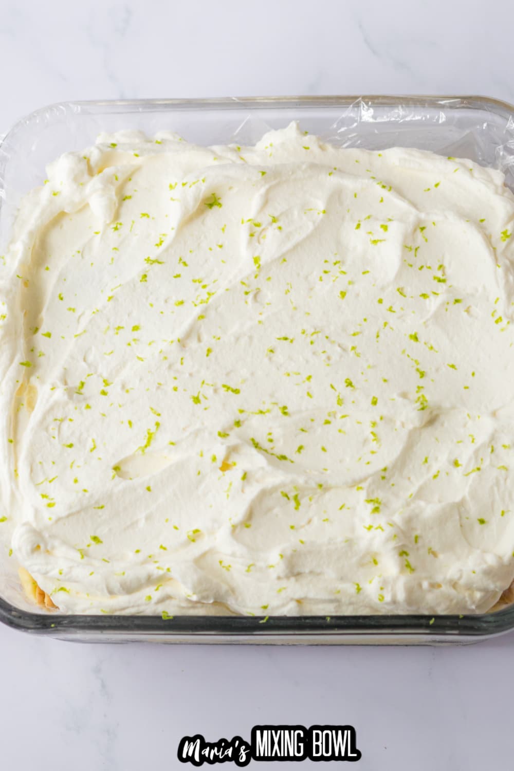 ice box cake being topped with whipped cream