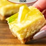 slice of lemon cheesecake bars held in a woman's hand.