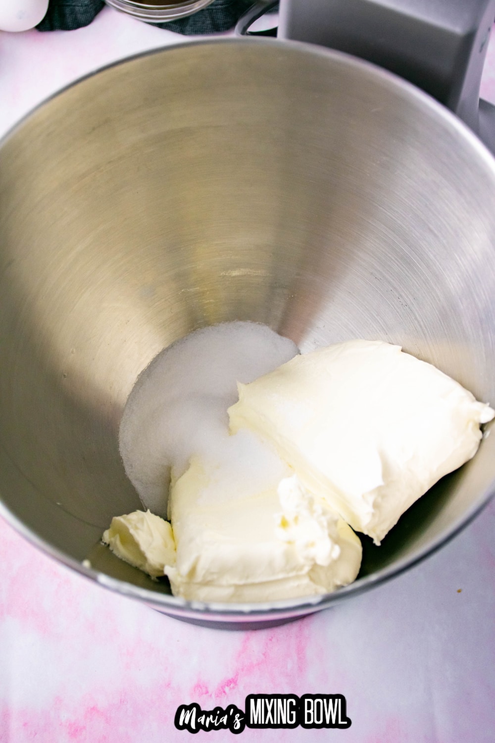 cream cheese and sugar in a stainless steel mixing bowl