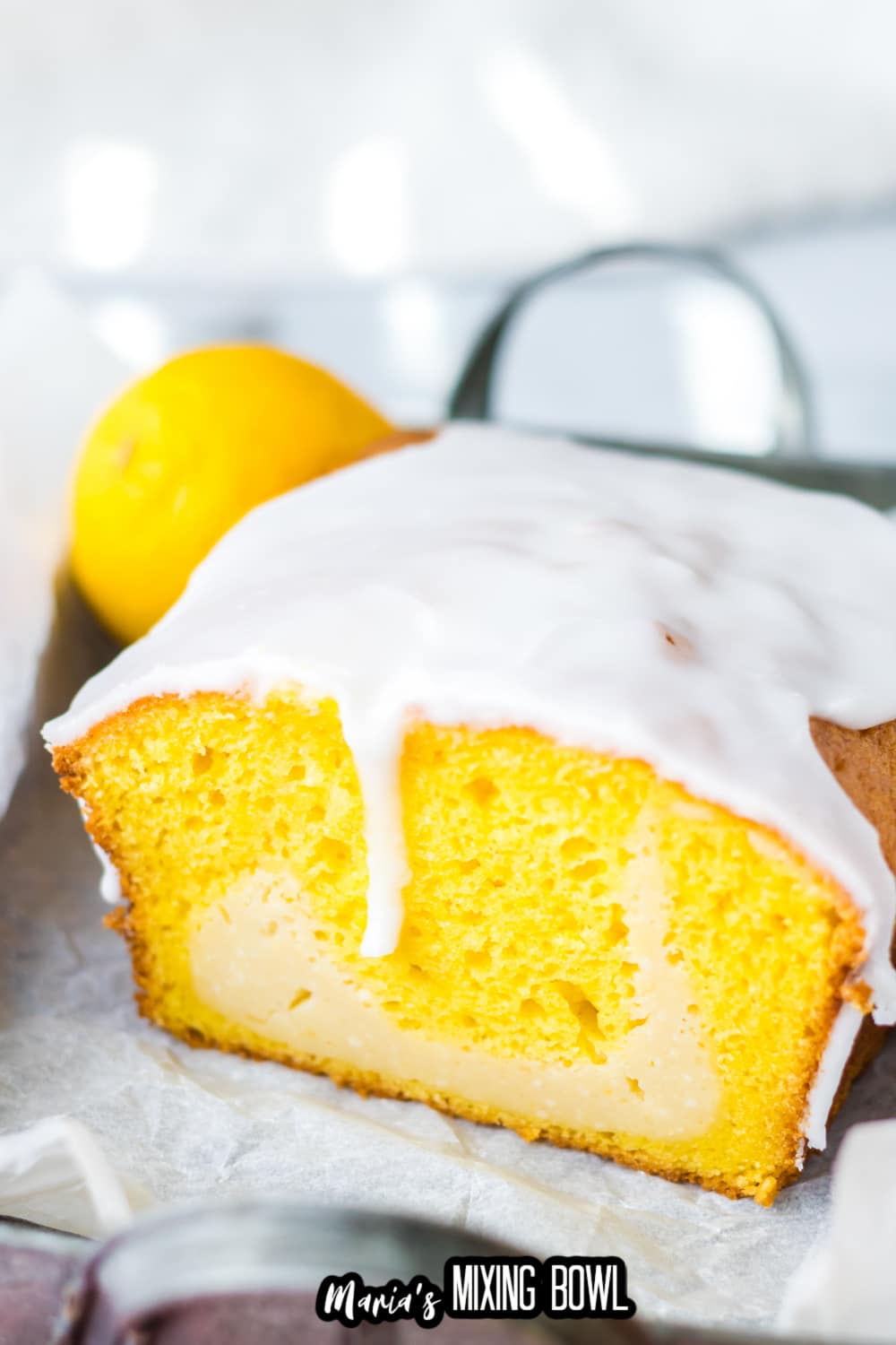 lemon loaf topped with glaze cut in half to show the inside