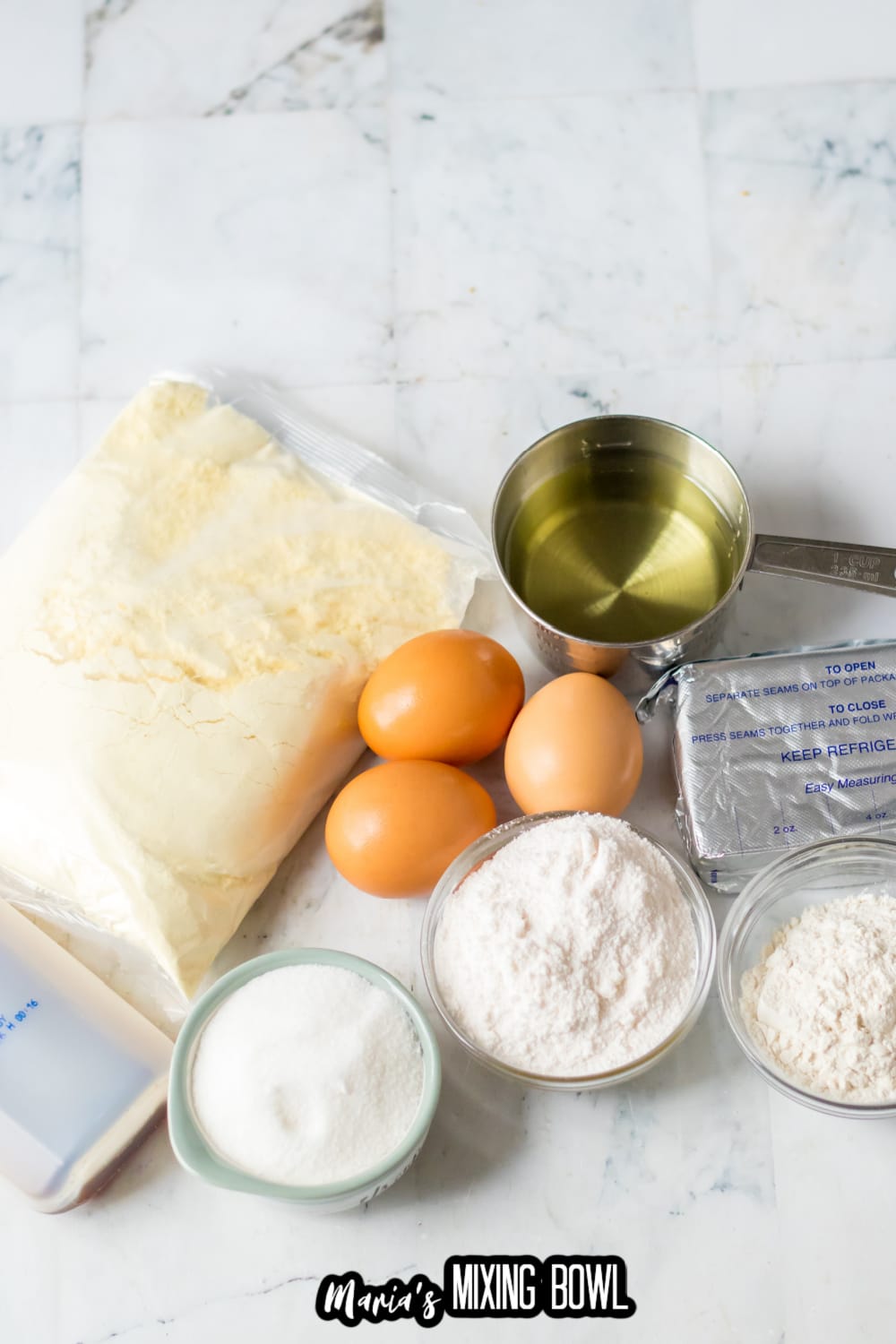 cake mix, oil, eggs, powdered sugar, sugar, and cream cheese on a marble backdrop