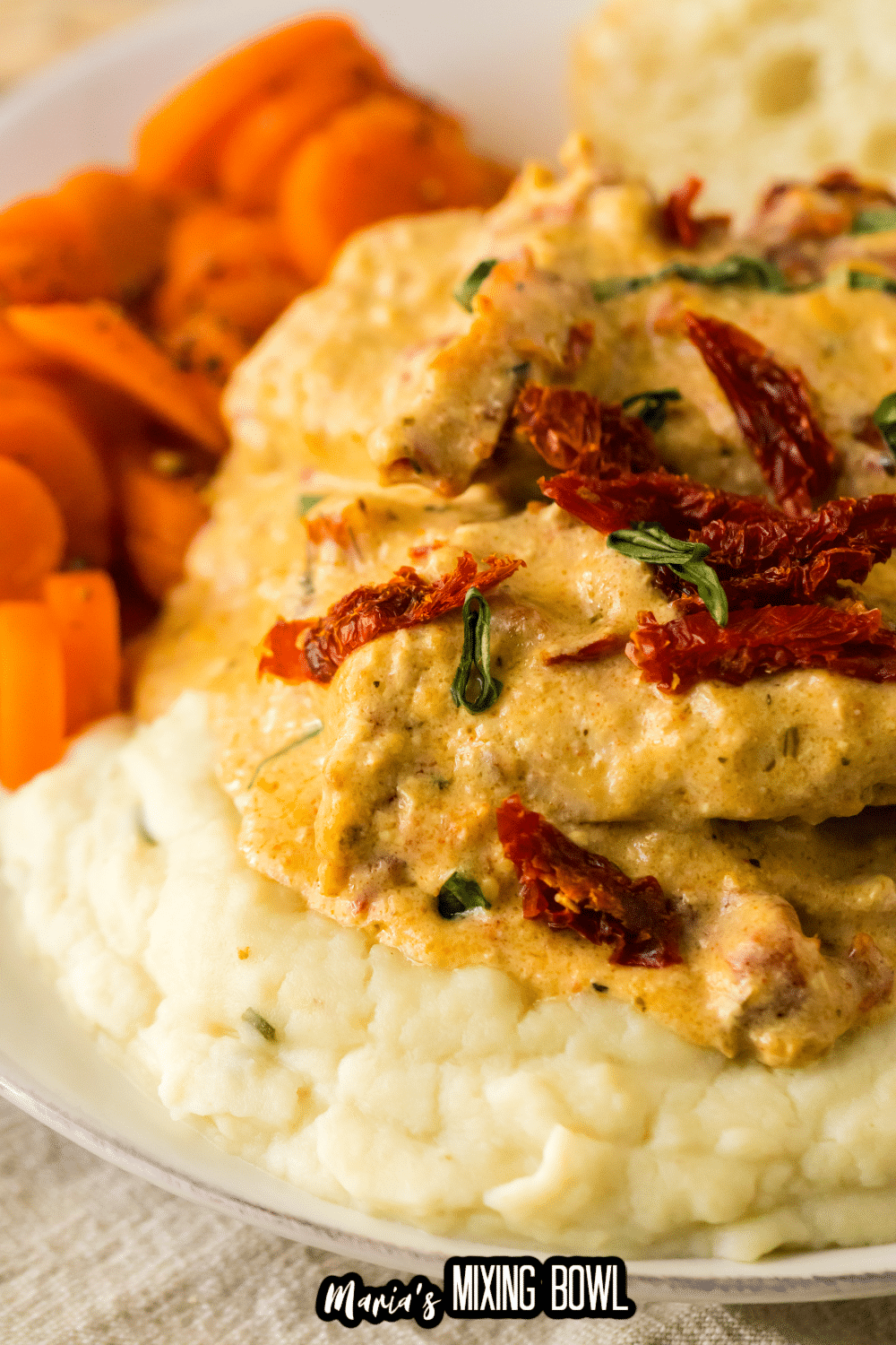 marry me pork chops stacked on top of mashed potatoes on a white plate