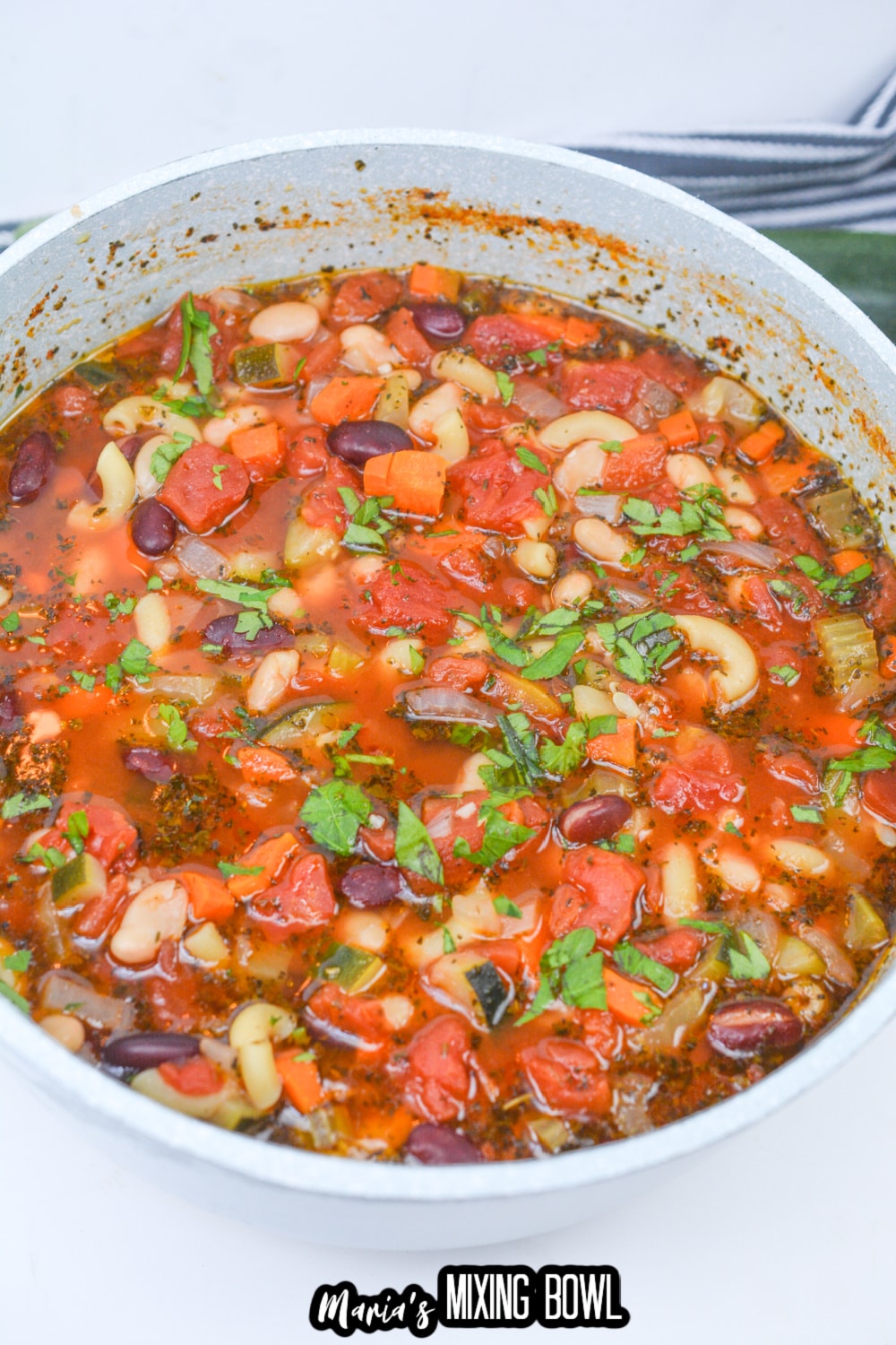 white dutch oven filled with minestrone soup