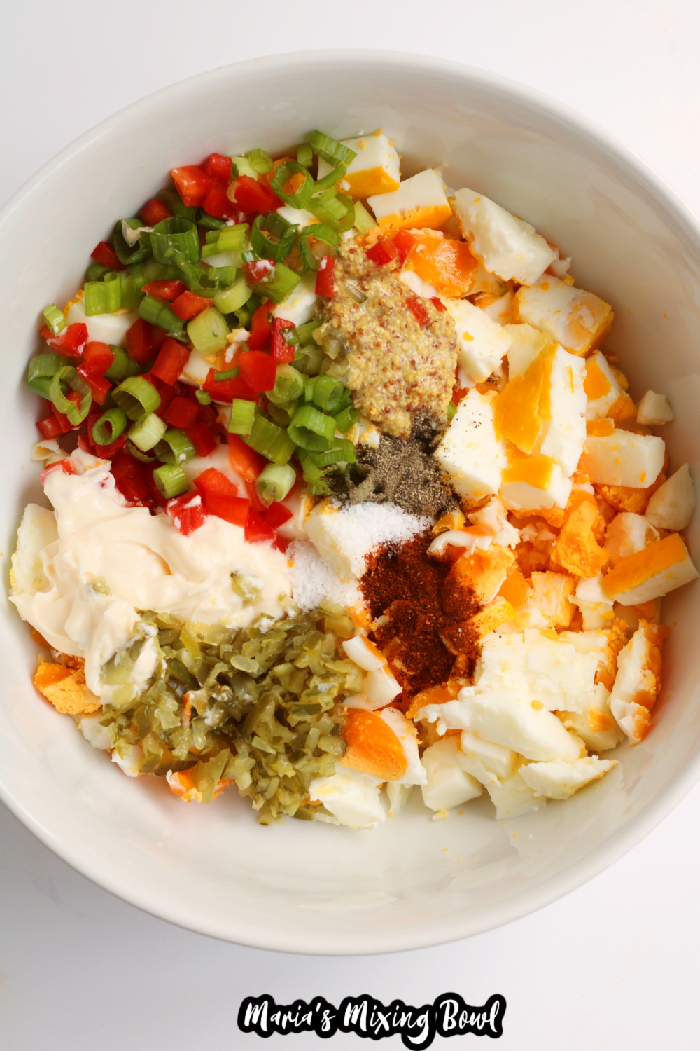 ingredients to make egg salad in a white mixing bowl
