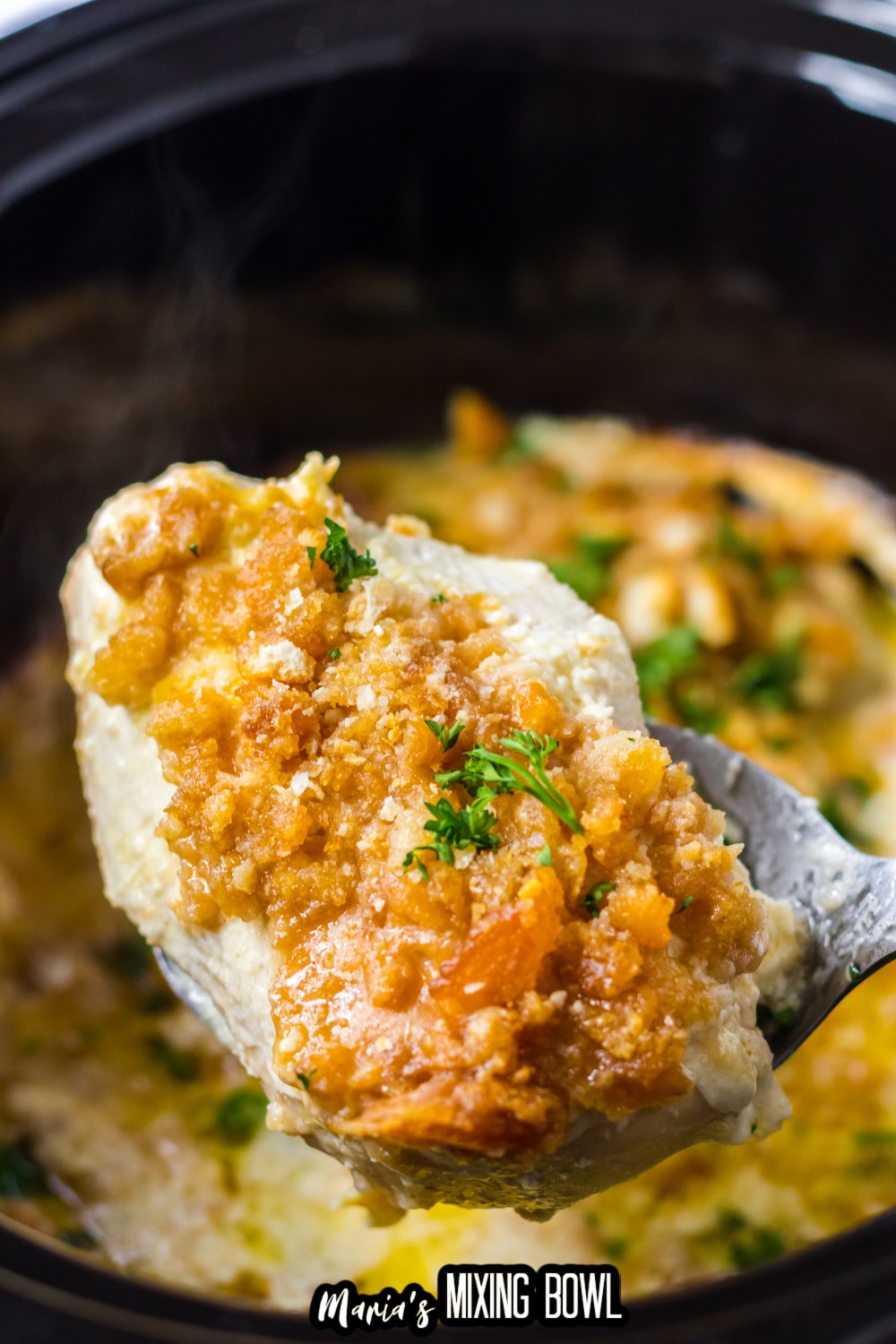 ritz cracker chicken held on a spoon in the air over a slow cooker