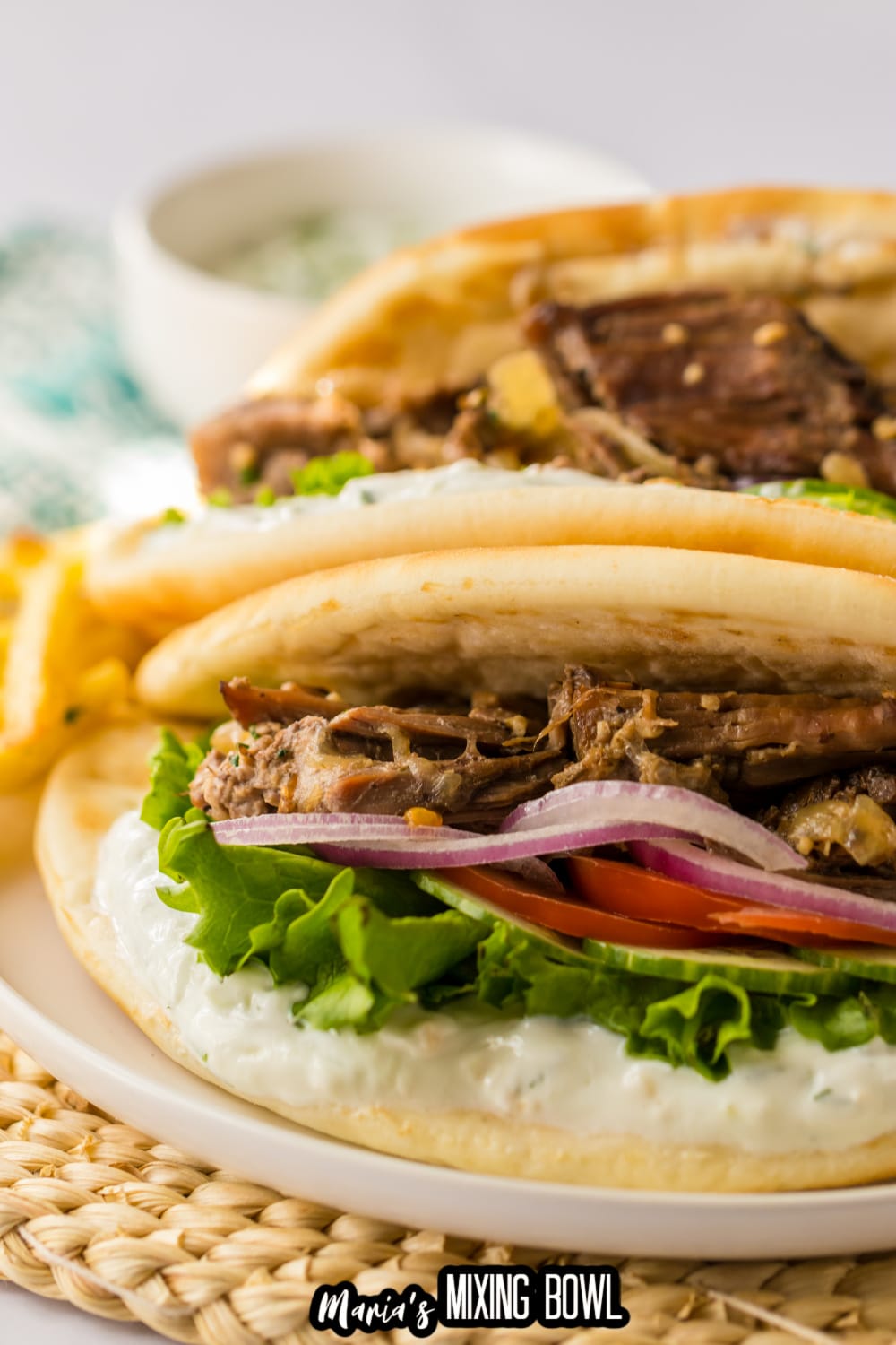 two slow cooker gyros on a white plate
