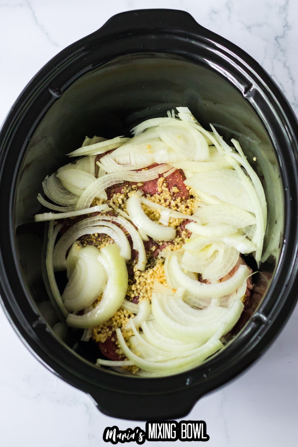 onions, garlic, and beef in a slow cooker