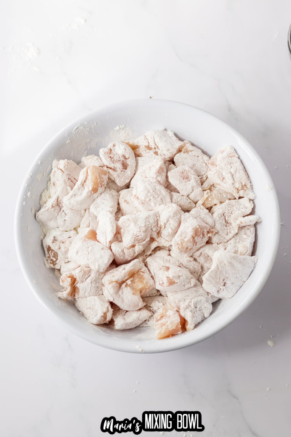 diced chicken breasts being breaded