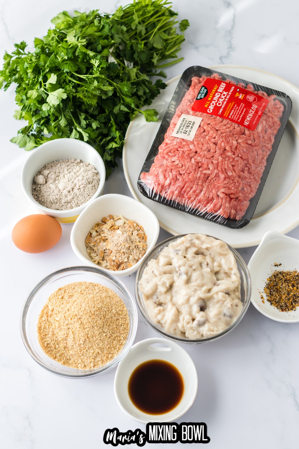 ground beef, parsley, gravy mix, cream of mushroom soup, breadcrumbs, egg and seasonings on a white background