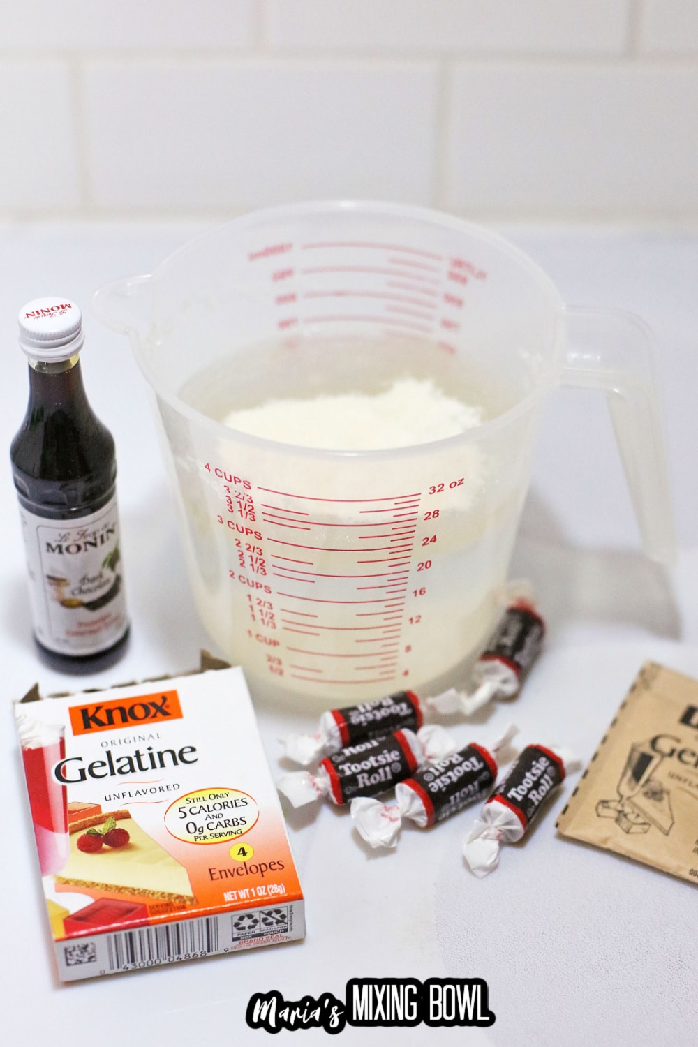 syrup, water, gelatine, and tootsie rolls on a white background