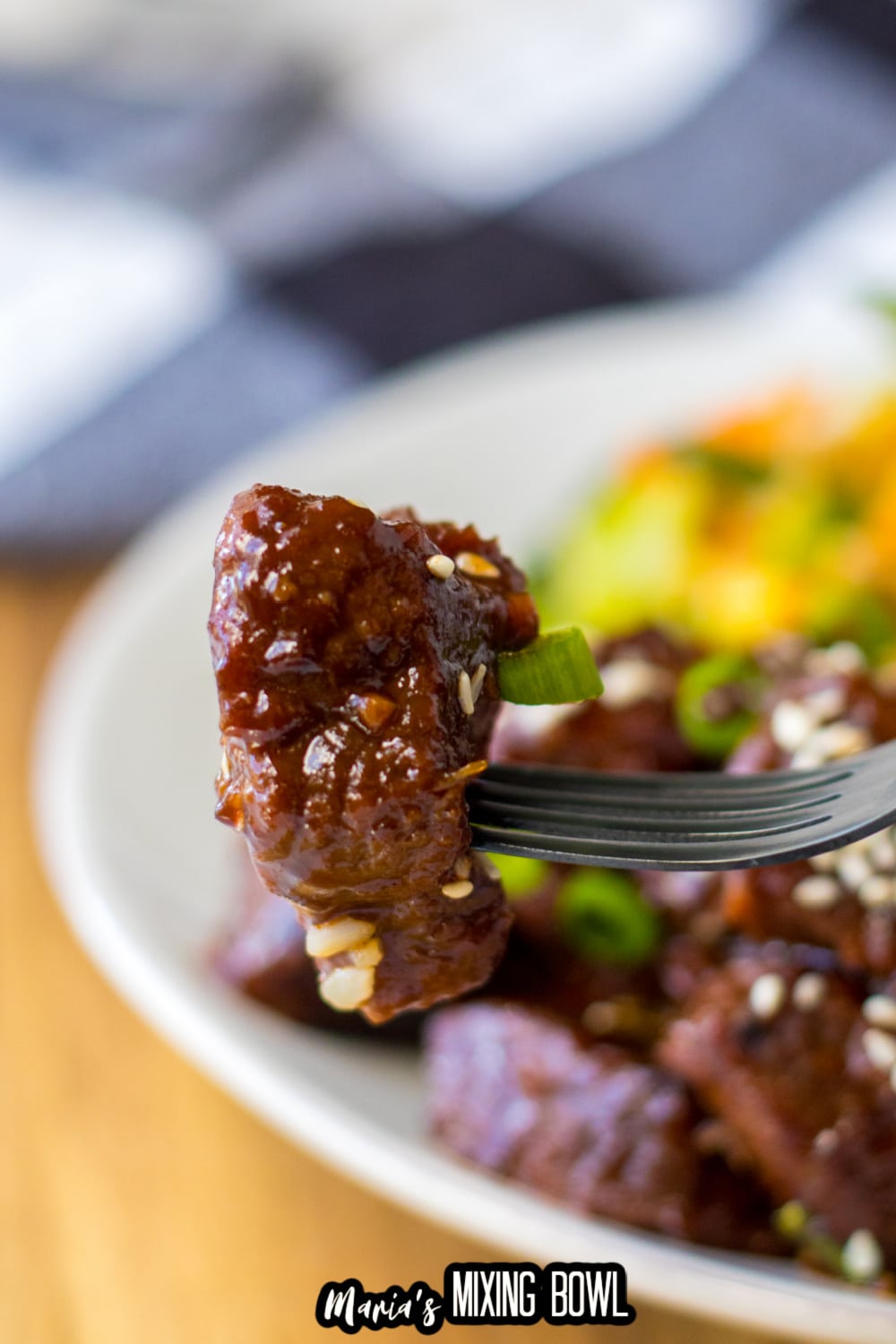garlic butter steak bite held in the air on a stainless steel fork