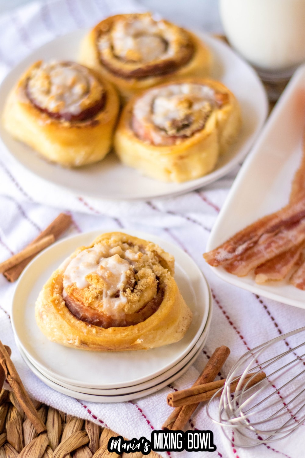 bacon cinnamon roll on three stacked small plate