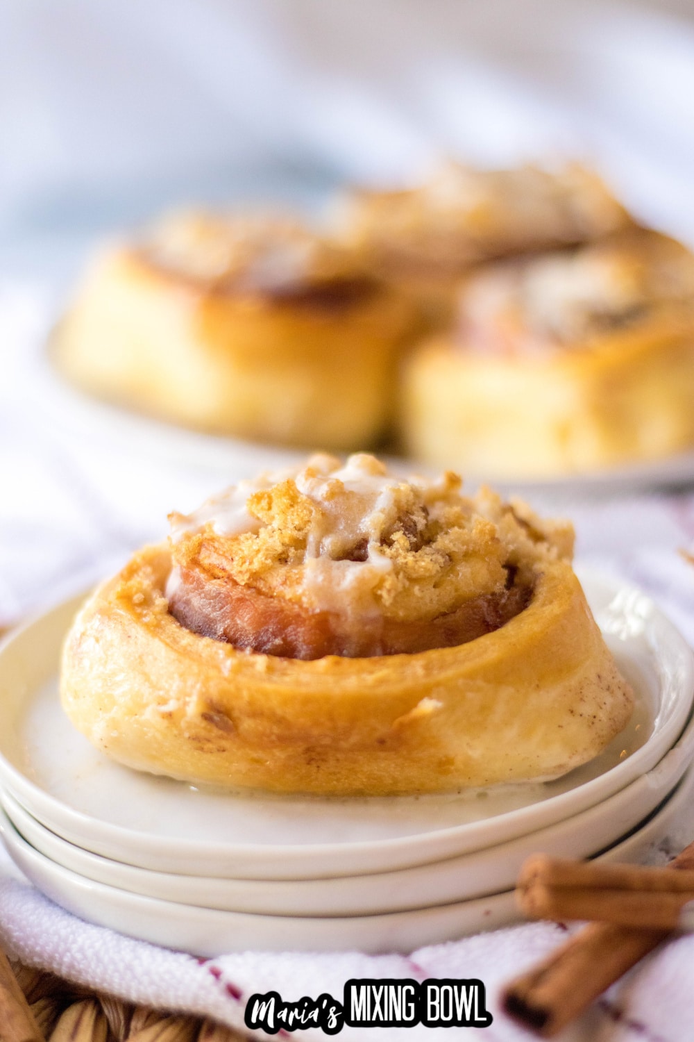 bacon cinnamon roll on a stack of three small plates