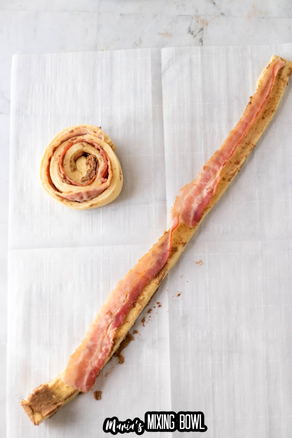 bacon being rolled up into a cinnamon roll