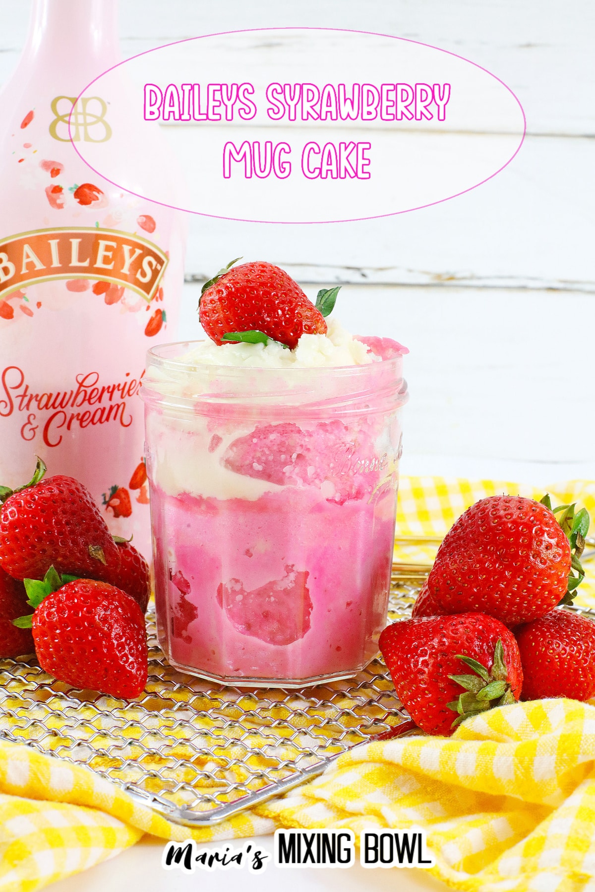 mason jar filled with strawberry mug cake and topped with whipped cream and a fresh strawberry
